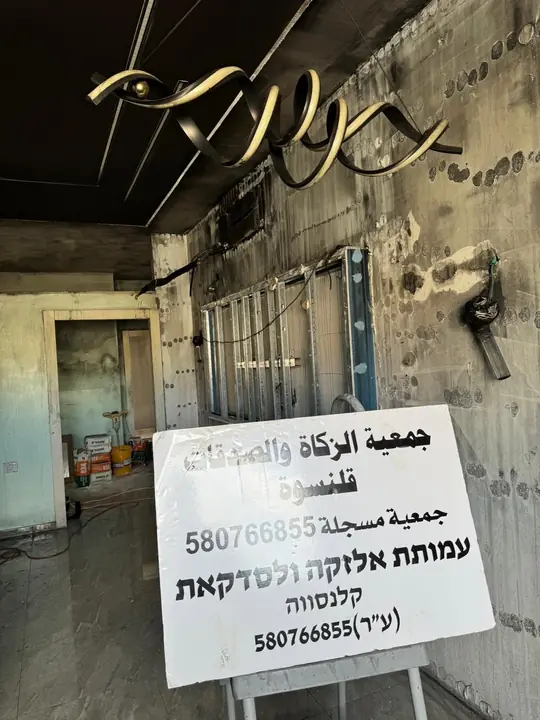 لافتة اللجنة داخل البيت المحترق أثناء الترميم